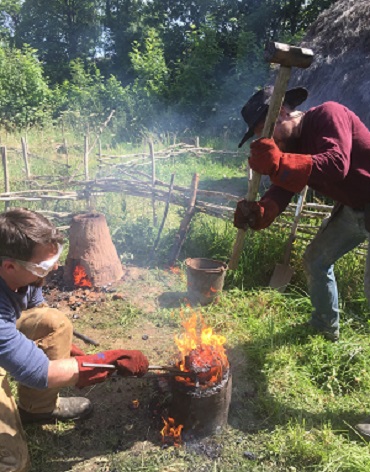 UCD Archaeology PhD scholar Brendan O'Neill and MSc in Experimental Archaeology Crtomir Lorencic consolidating iron bloom from a furnace at CEAMC